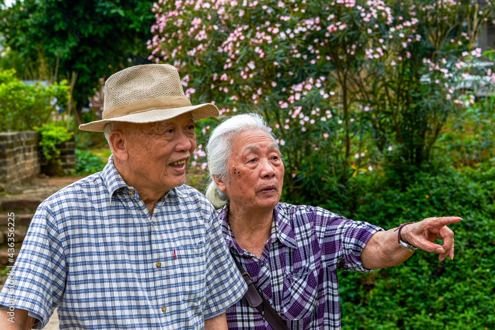 Two Asian old men happily strolling in the park, smiling Two Asian old men happily strolling in the park, smiling
