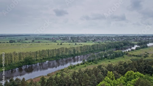 Top view of the river, surrounded by trees and meadows photo