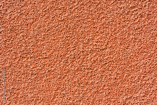 Red concrete wall with small stones