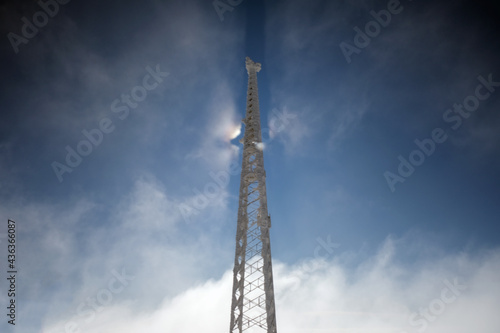 mobile phone base station pole on a sunny cloudy and foggy day