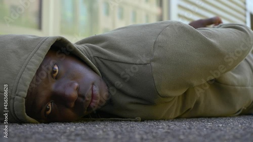 protest symbol - black man lying on the ground stares at camera photo