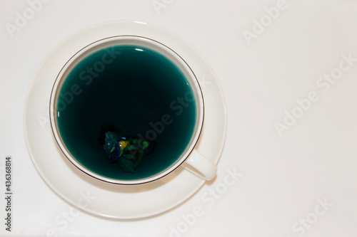 The mood color is blue - blue tea in a white mug, which stands on a white saucer and a white tray.