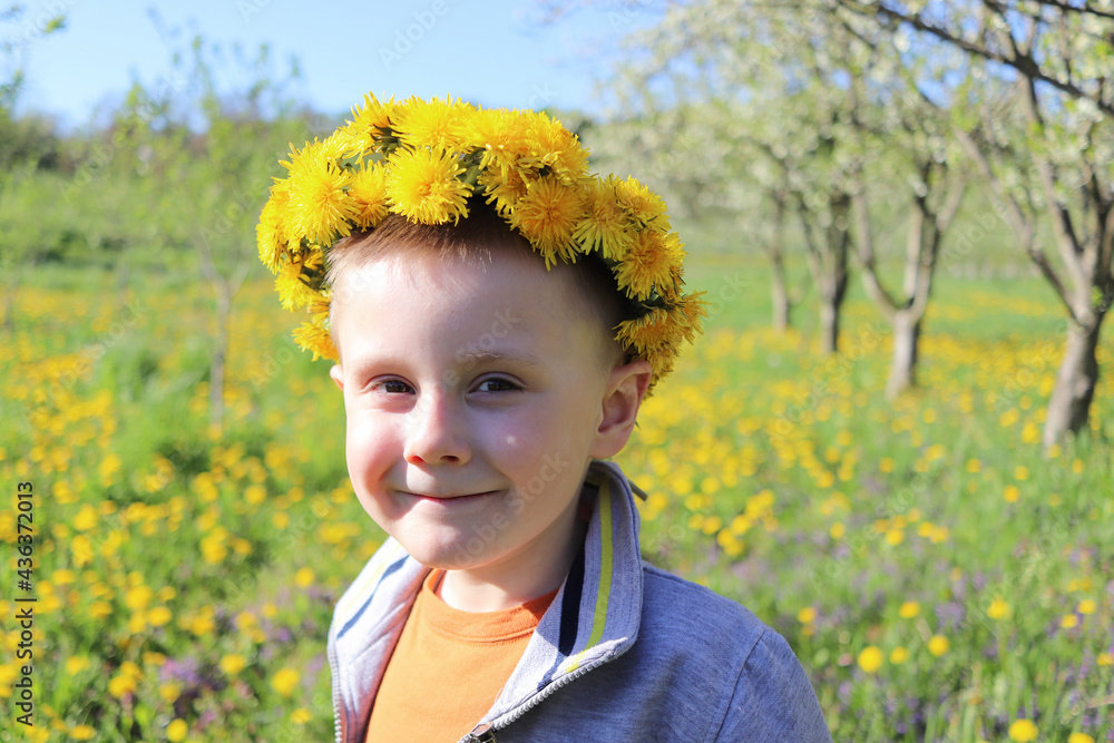 Outdoor portrait of a smiling little boy with a dandelion crown on his head. Outdoor portrait of a smiling little boy with a dandelion crown on his head.