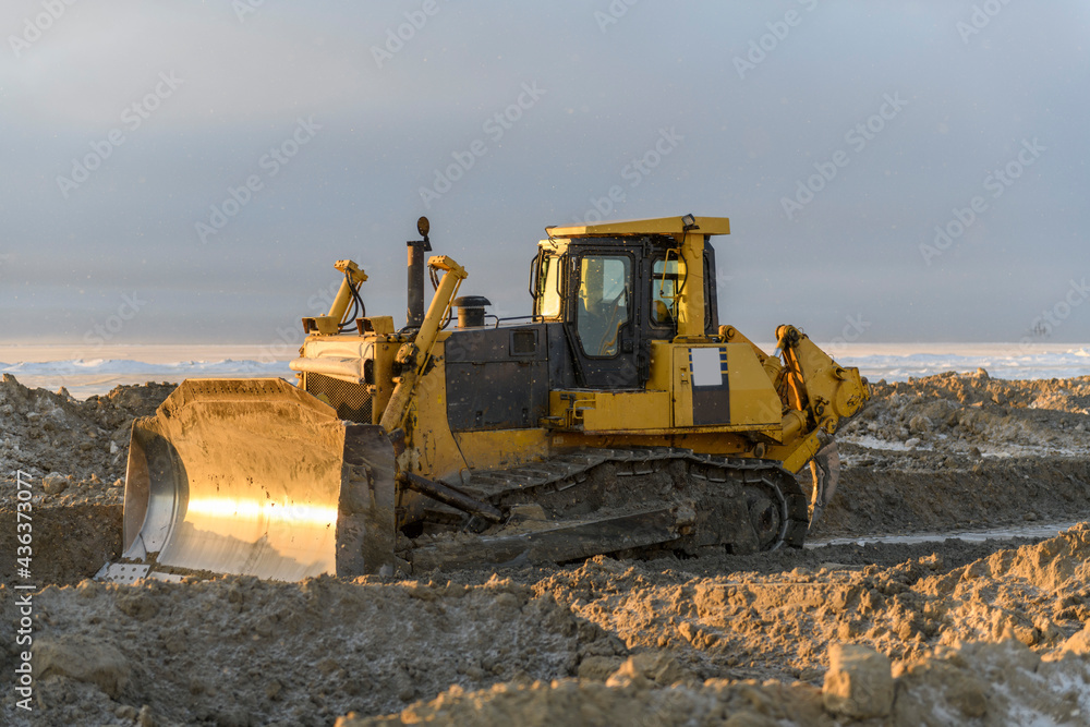 Yellow tractor in winter tundra. The road construction. Bulldozer. Yellow tractor in winter tundra. The road construction. Bulldozer.
