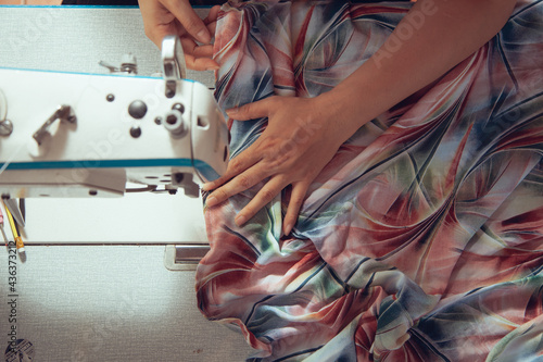 A seamstress quickly tailors the clothes. In order to deliver customers in time to see the top view photo