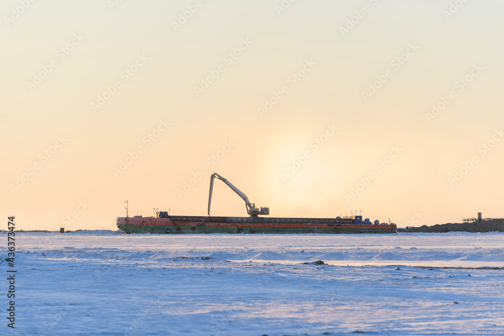  Barge with crane. Dredger working at sea. Sunset in Arctic sea. Construction Marine offshore works. Dam building, crane, barge, dredger.