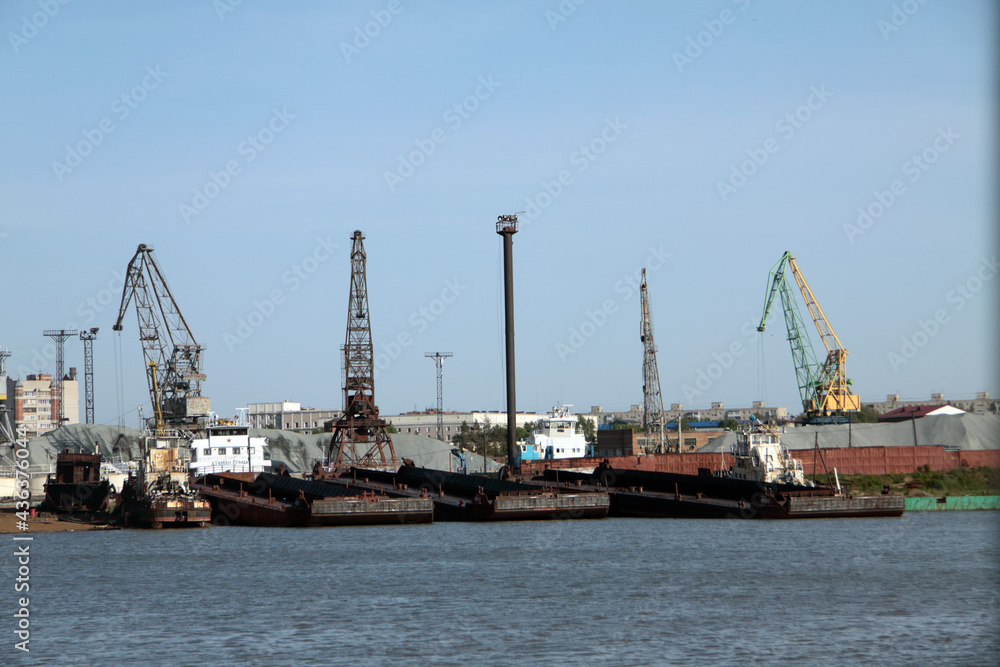 Cityscape - view over river port with cranes and barges