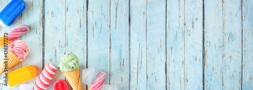 Collection of colorful summer popsicles and ice cream desserts. Above view corner border on a rustic blue wood banner background. Copy space.