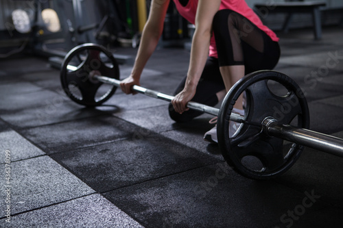 Φωτογραφία Cropped shot of unrecognizable sportswoman preparing to lift barbell at gym