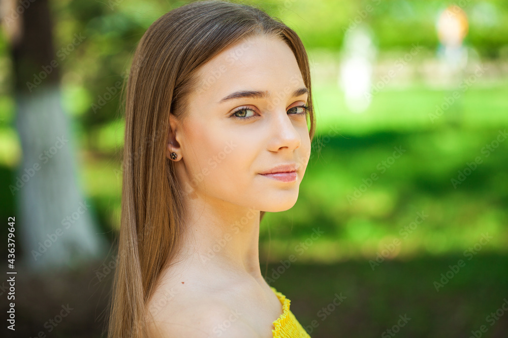Portrait of a teenage girl on the background of a city park Portrait of a teenage girl on the background of a city park