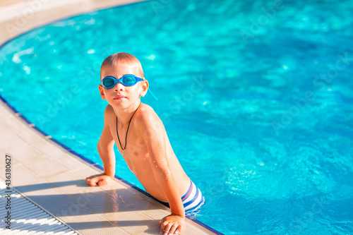 Cute happy little boy in goggles swimming and snorking in the swimming pool © len44ik
