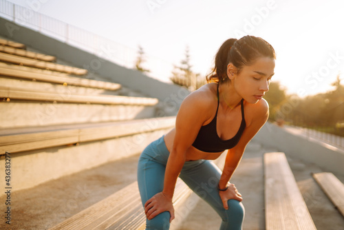 Young woman in sportswear doing exercises outdoors in the morning. Warming up your muscles before an intense workout. Sport, Active life, sports training, healthy lifestyle.