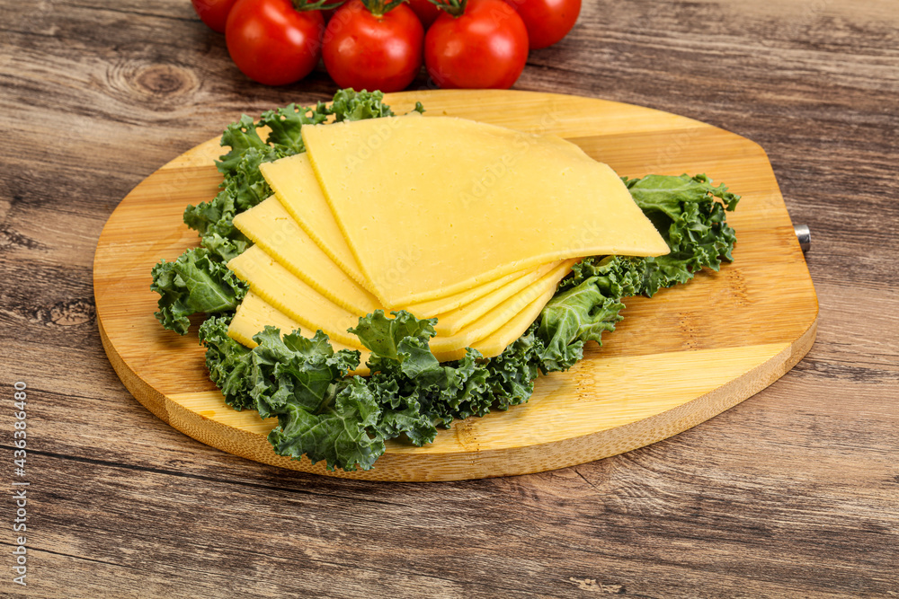 Sliced Gauda cheese over board Sliced Gauda cheese over board