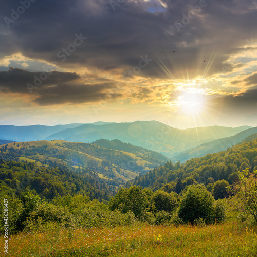 countryside landscape in summer at sunset. beautiful nature scenery with meadows on the hills rolling in to the distant valley in evening light