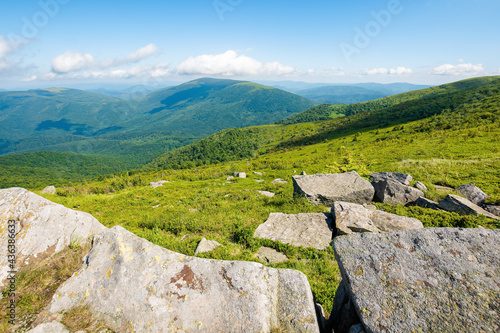 summer mountain landscape. stones on the hillside meadow. beautiful view in to the distant valley on a bright summer day. wonderful nature of carpathian mountains, ukraine