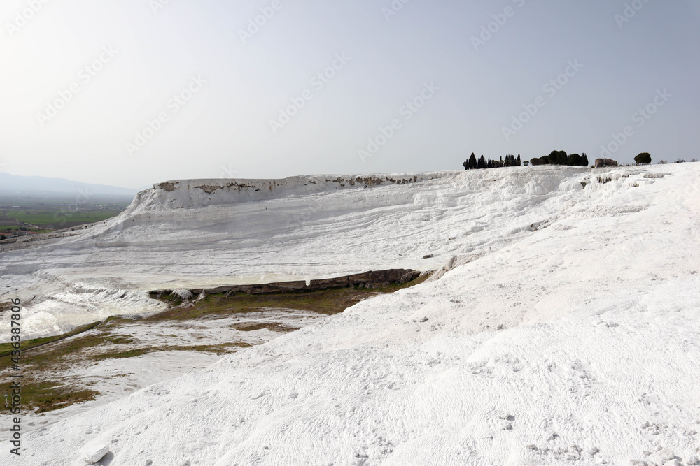 slopes of the valley covered by white carbonate mineral formations, travertines of Pamukkale, Turkey slopes of the valley covered by white carbonate mineral formations, travertines of Pamukkale, Turkey