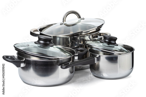 Ladle and two stainless steel pans with glass lids. Isolated on white background.