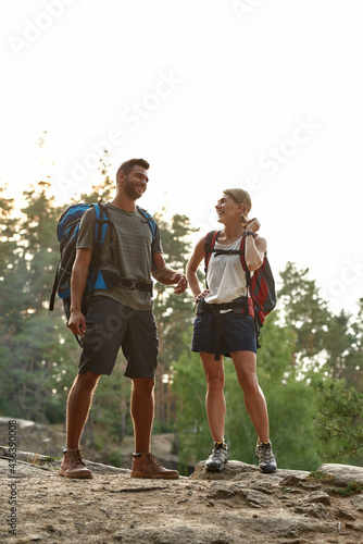 Laughing young caucasian couple standing on rock