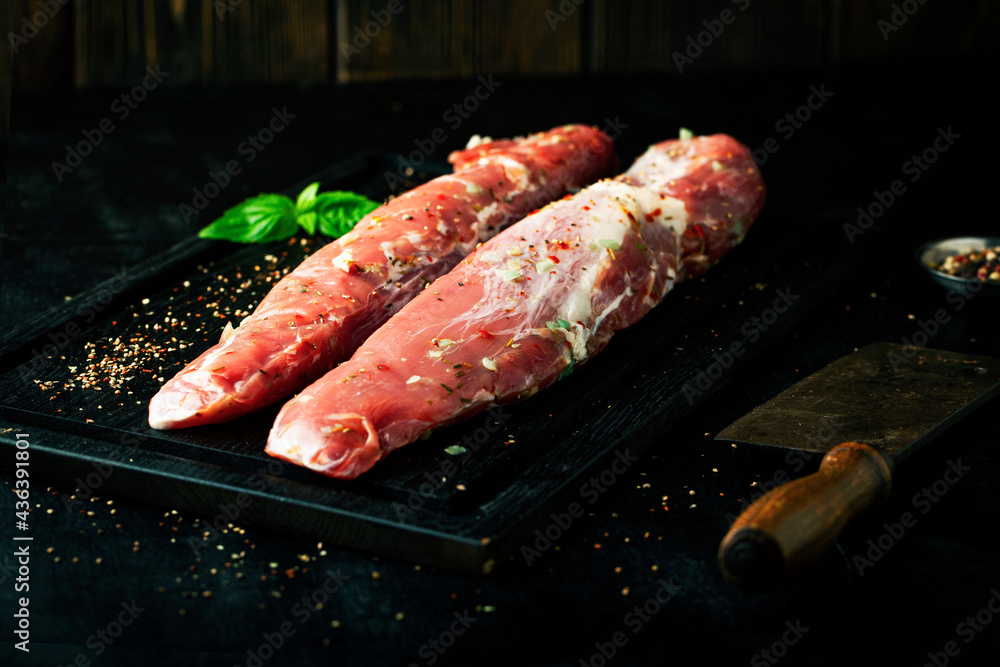 Fresh raw meat marinated with spices on a dark background