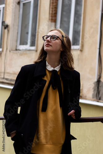 Teen girl in a white shirt, black stockings glasses on a walk in the old town © Світлана Коваль