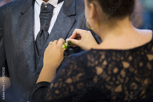 ceremonial placing a flower in the groom's suit