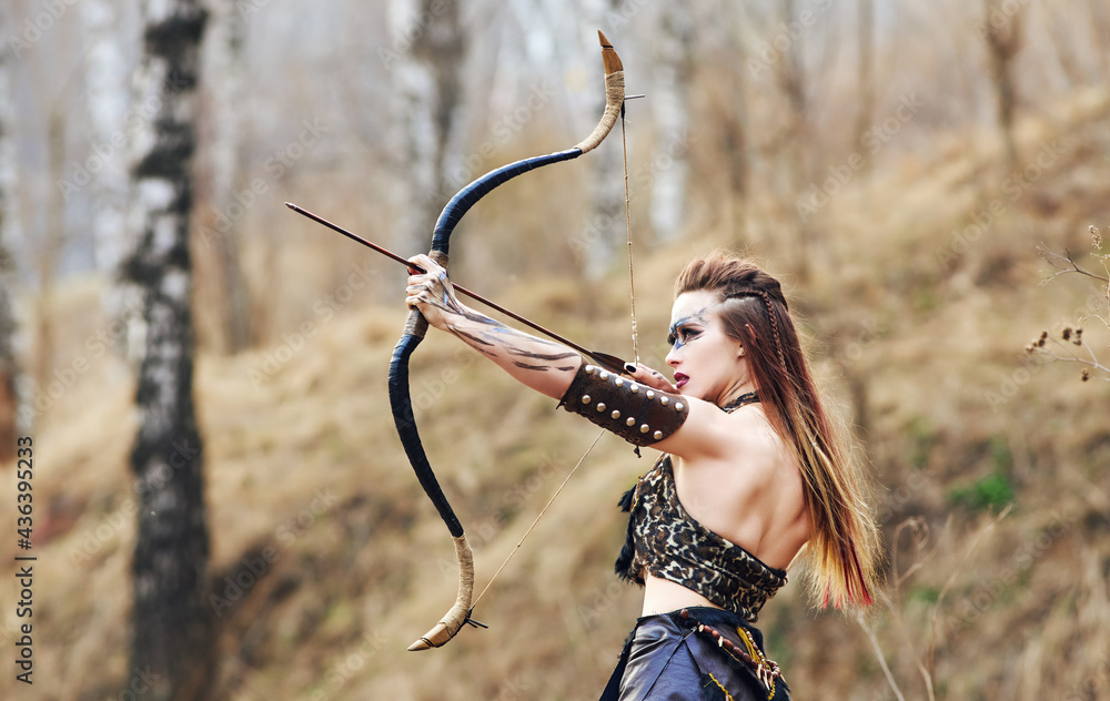 Beautiful amazon woman posing with bow
