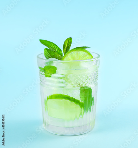 Mojito in a glass beaker on a blue background.