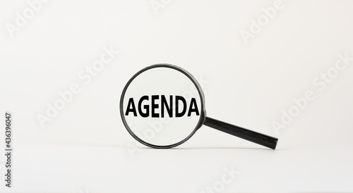 Agenda symbol. Magnifying glass with the concept word agenda on beautiful white background. Business and agenda concept, copy space.