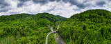 Road Trough Bieszczady Mountains. Green Forest and Wilderness. Drone Panoamic View