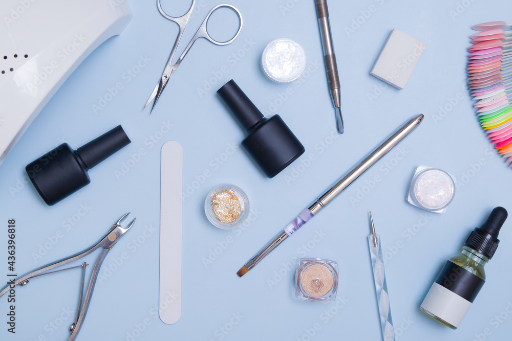 Top view of tools and materials for modern manicure and nail extension. Knolling on a blue background. Flat lay manicure tools Top view of tools and materials for modern manicure and nail extension. Knolling on a blue background. Flat lay manicure tools