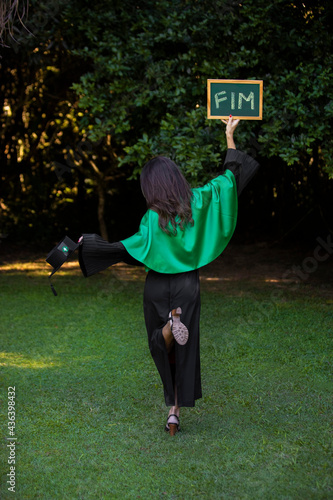 graduate holding a sign written end