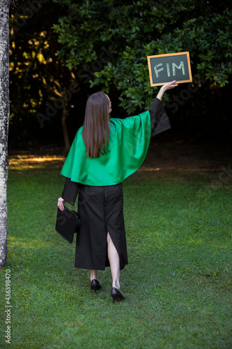 graduate holding a sign written end