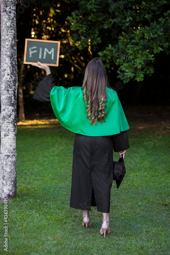 graduate holding a sign written end