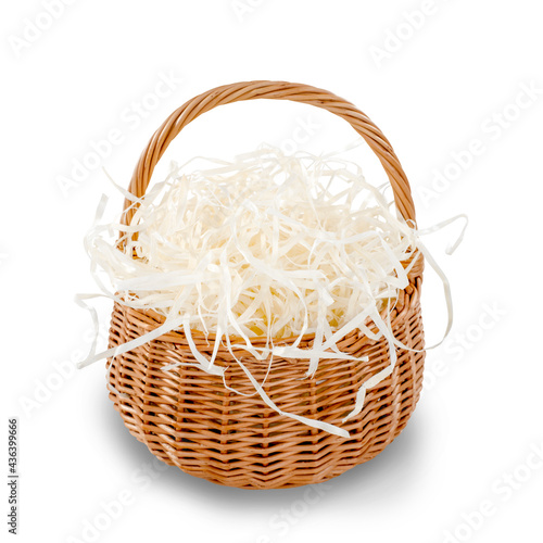 Wicker basket filled with decorative shredded white paper straw. Isolated on white. Clipping path included. Shallow Depth of Field. SDF.