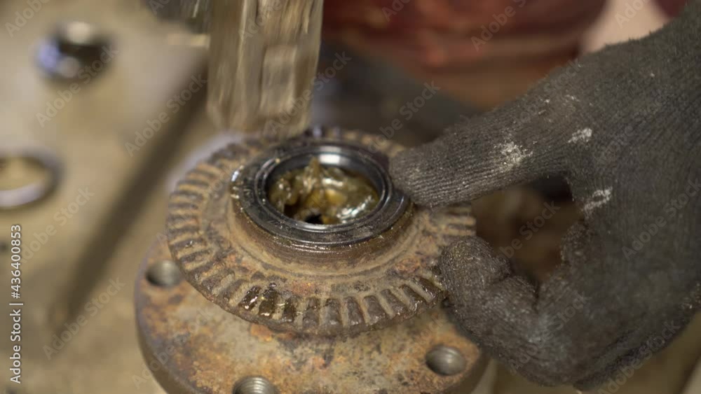 The master's hands install the oil seal and push it into the hub with hammer blows. Car repairs, replacement of bearings. The master's hands install the oil seal and push it into the hub with hammer blows. Car repairs, replacement of bearings.