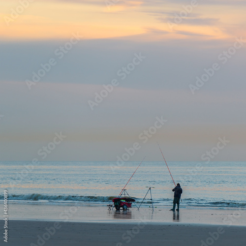 Silhouette of a fisherman with fishing line along the North Sea beach, Oostende (Ostend), Belgium.