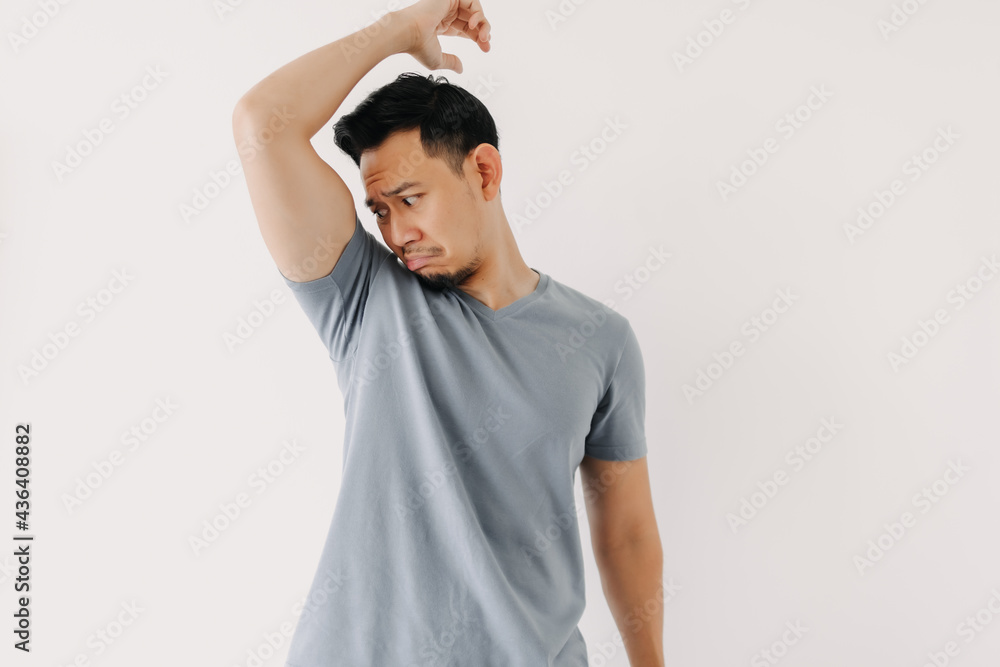 Asian man smells his bad odor armpit isolated on white background. Asian man smells his bad odor armpit isolated on white background.