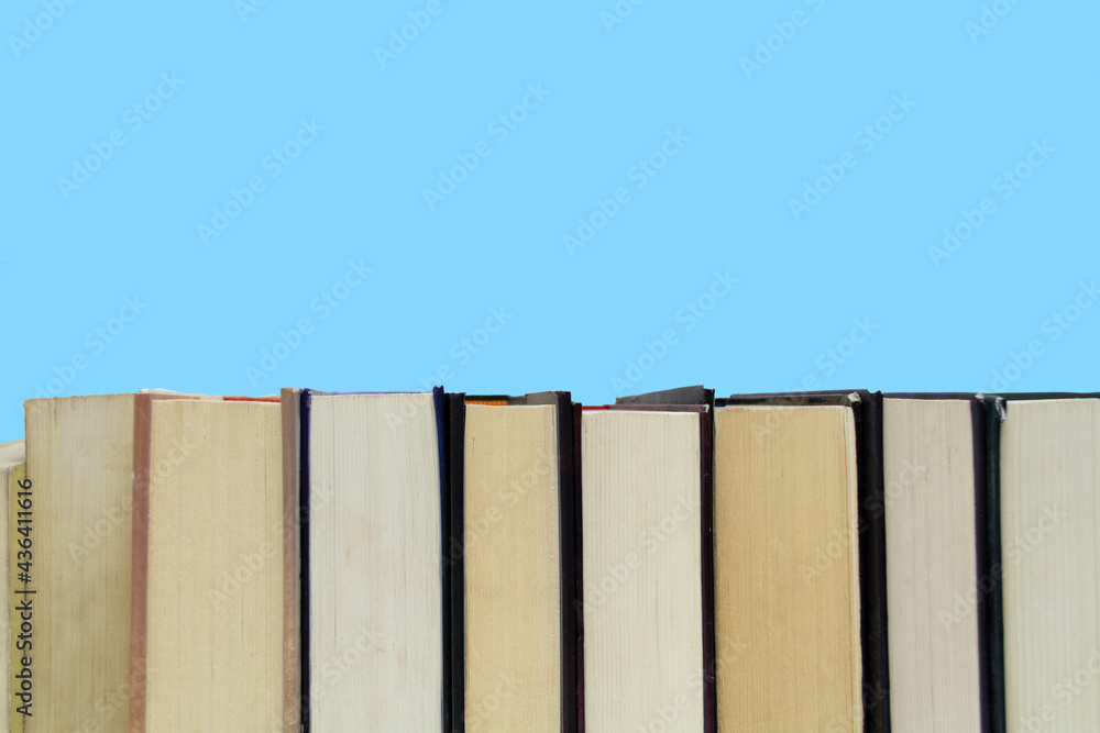 Stack of colorful books, grungy blue background, free copy space Vintage old hardback books on wooden shelf on the deck table, no labels, blank spine. Back to school. Education background Stack of colorful books, grungy blue background, free copy space Vintage old hardback books on wooden shelf on the deck table, no labels, blank spine. Back to school. Education background