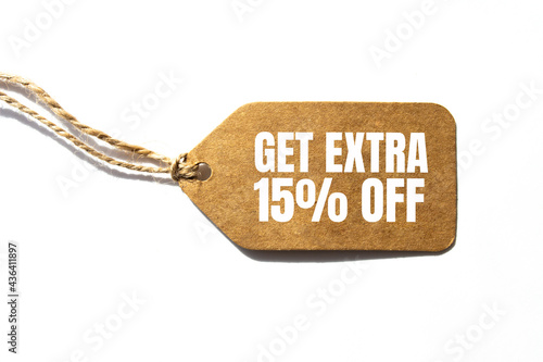 GET EXTRA 15 OFF percent text on a brown tag on a white paper background