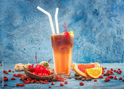 Closeup of a glass of delicio iced orange shake with berries and pomegranate on the table photo