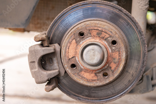 Old car brake disc. The brakes on the car require regular maintenance. Very close-up of the brake disc and pads when replacing the wheel.