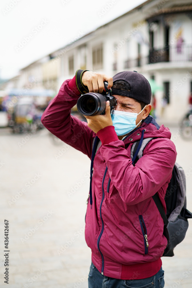fotógrafo hispano fotografiando con tapabocas fotógrafo hispano fotografiando con tapabocas