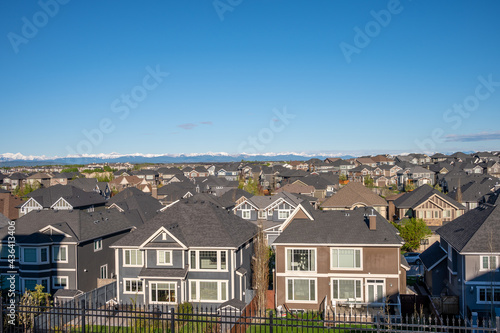 Roof top view of modern suburban home in Calgary with mountain in the background. 