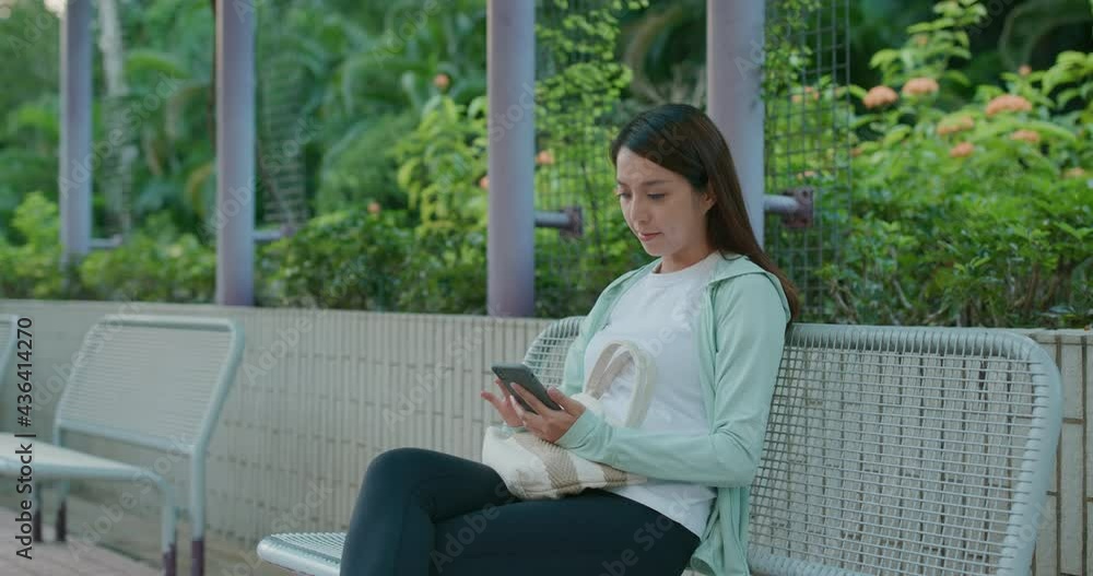 Woman use of mobile phone and sit on the park Woman use of mobile phone and sit on the park