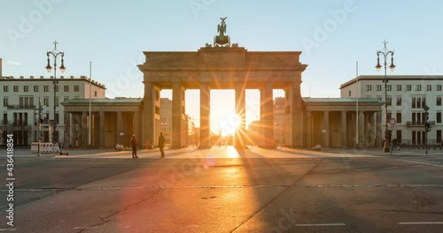 Timelapse of the sun rising behind the Brandeburg Gate in central Berlin, historic place of the Berlin Wall in 4k photo