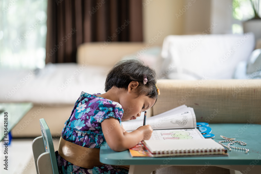 Adorable girl doing homework at table indoor. Adorable girl doing homework at table indoor.