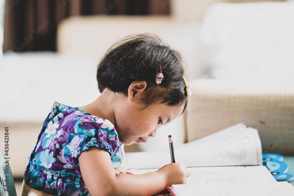 Adorable girl doing homework at table indoor. Adorable girl doing homework at table indoor.
