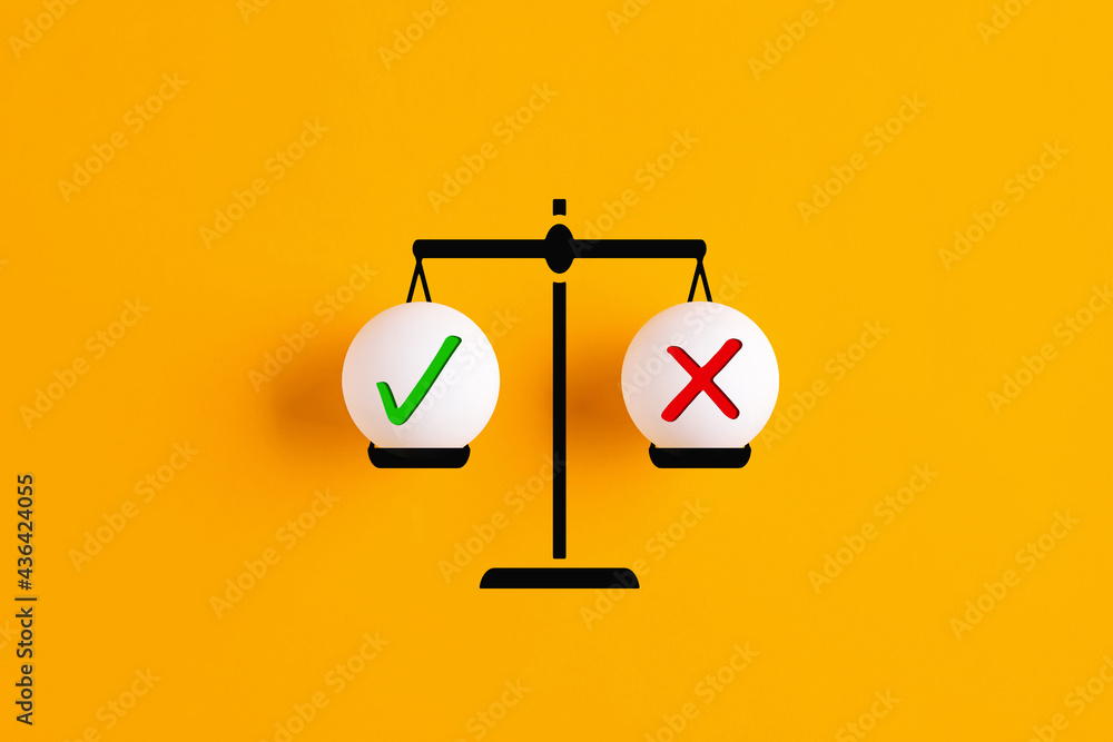 Right and wrong or yes or no symbols are in balance on a scale. Stock