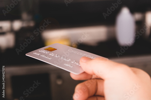 At a coffee shop, a female customer handed over a credit card. To pay for food, beverages, tea, and coffee At the bar counter