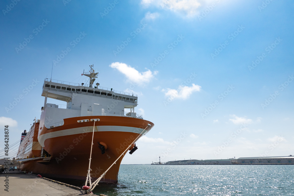 Cargo ship anchored in port. Blue Sky Background Cargo ship anchored in port. Blue Sky Background
